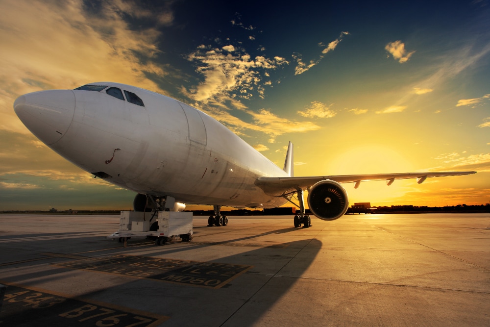 primer plano de un avión con atardecer de fondo